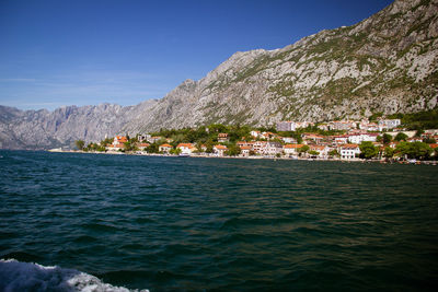 Scenic view of sea and buildings against blue sky