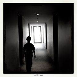 Rear view of woman walking in corridor