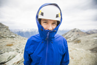 Portrait of mountain climber wearing helmet and rain jacket.