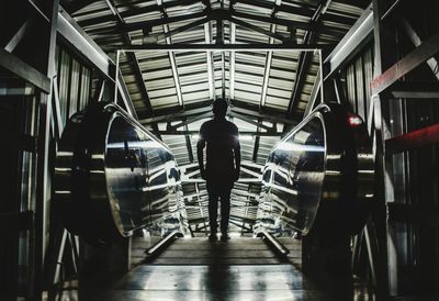 Rear view of silhouette man on illuminated escalator at railroad station