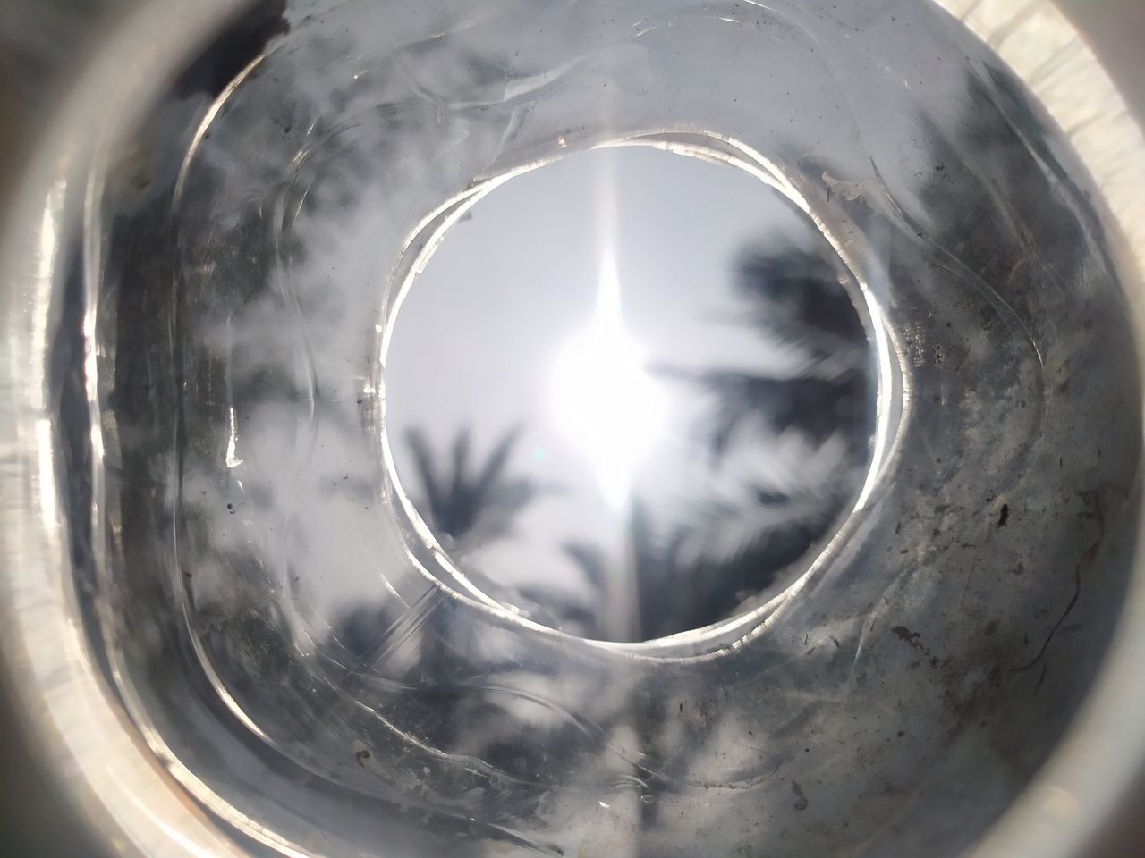 CLOSE-UP OF GLASS WITH REFLECTION OF HOLE