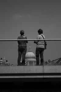 Rear view of people on bridge looking at st paul cathedral against dome