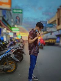 Full length of boy standing on road in city