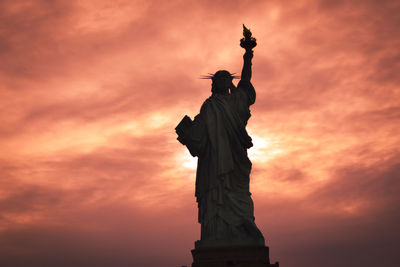 Low angle view of statue against cloudy sky during sunset