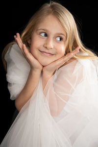 Portrait of a smiling girl over black background