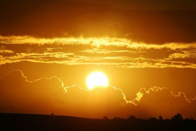 Scenic view of silhouette landscape against dramatic sky during sunset