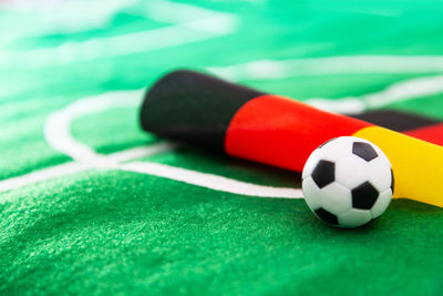 Close-up of small soccer ball with flag on green textile