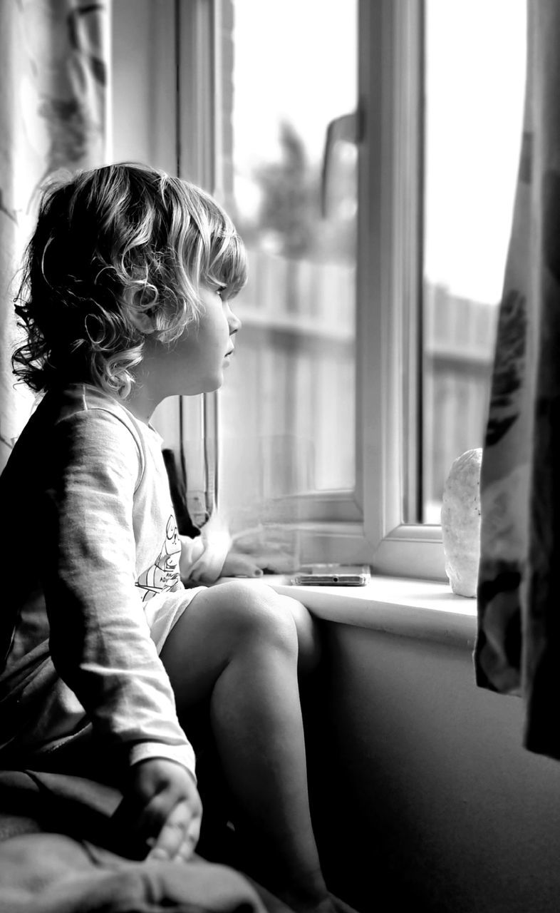 SIDE VIEW OF GIRL LOOKING AT WINDOW