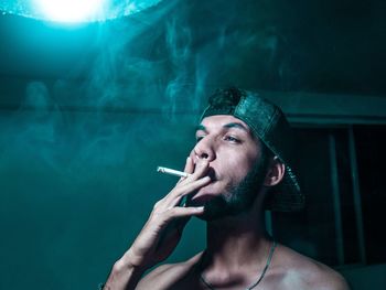 Portrait of young man smoking cigarette