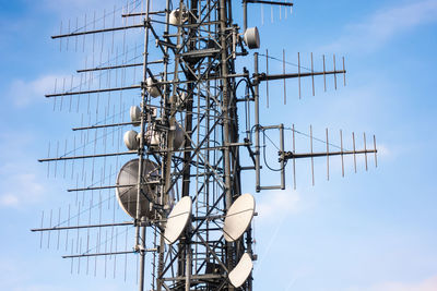 Low angle view of communications tower against sky