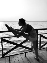 Smiling woman stretching on railing