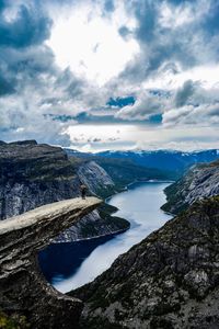 Woman standing on rock formation over lake