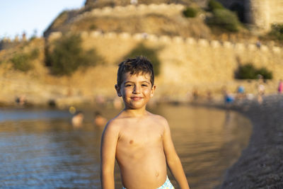 Portrait of shirtless boy standing in water