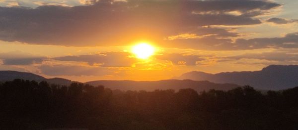 Scenic view of silhouette mountains against sky during sunset