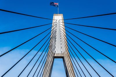 Low angle view of suspension bridge with australian flag against sky