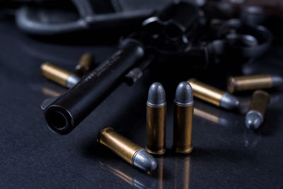 Close-up of bullets and handgun on table