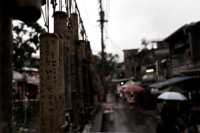 Wooden prayer block hanging over street at dusk