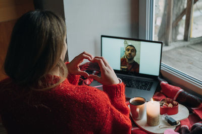 Woman using laptop on table at home