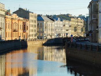 Reflection of cityscape in water against sky
