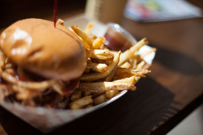 Burger with french fries on paper plate