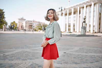 Smiling young woman standing in town