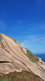 Scenic view of sea and mountains against blue sky