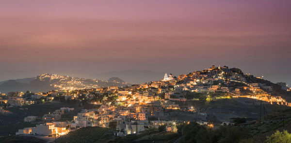 Illuminated cityscape against sky during sunset