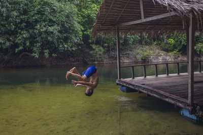 Side view of man in lake against trees