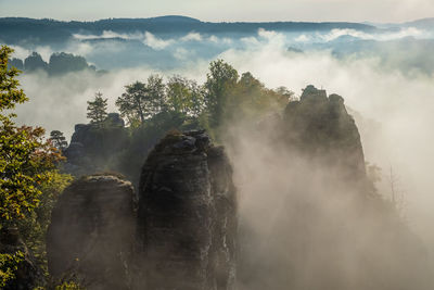 Scenic view of rock formation amidst fog