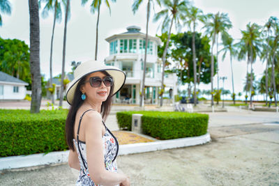 Portrait of smiling young woman wearing sunglasses standing outdoors