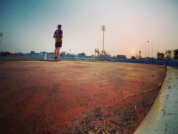 Rear view of man running on shore against sky