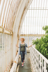 Full length of woman standing by railing