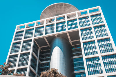 Low angle view of modern building against blue sky