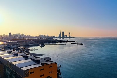 Scenic view of sea and buildings against sky during sunset