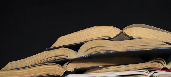 Low angle view of books against black background