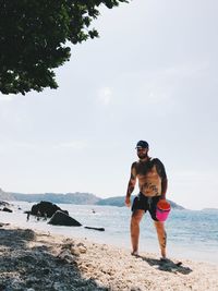 Full length of men on beach against sky