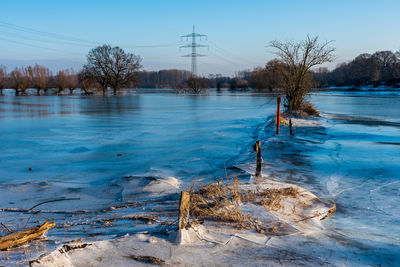 Scenic view of frozen river against sky during winter