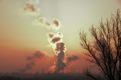 Smoke emitting from chimney against sunset sky