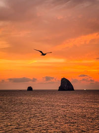 Scenic view of sea against orange sky