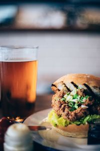 Close-up of burger and iced tea on table