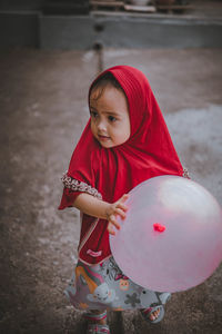 Cute little girl playing with balloons in the yard