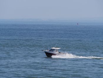 Boat sailing in sea against sky