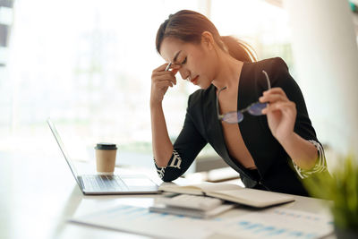 Side view of businesswoman working at table
