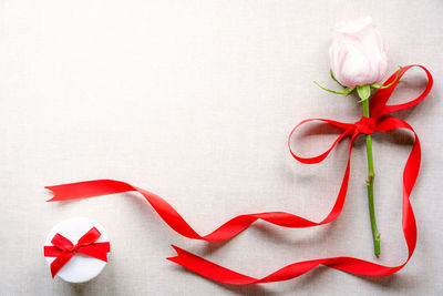 Close-up of rose and gift on table