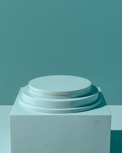 Close-up of stack of empty table against blue wall