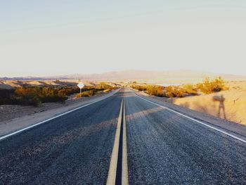 Road amidst desert against clear sky