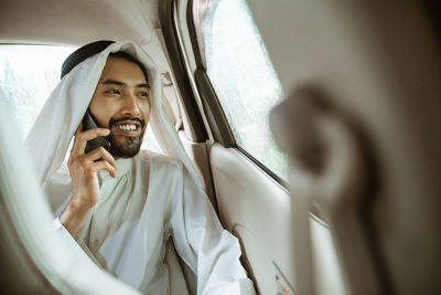 Portrait of young woman sitting in car