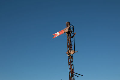 Low angle view of communications tower against clear blue sky old train station 