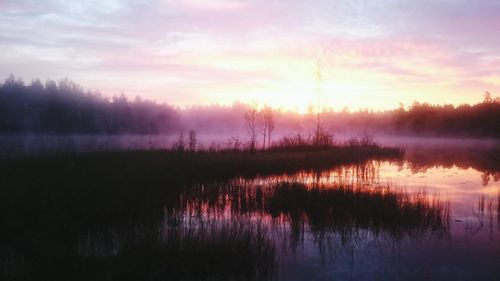 Scenic view of calm lake at sunset