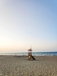 Lifeguard hut on beach against clear sky